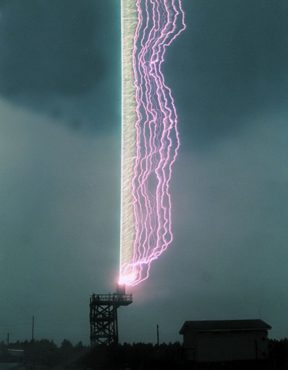 FORSKNINGSLYN:Ved University of Floridas forskningsstasjon for lyn utløses lyn ved å avfyre en rakett som trekker en metalltråd etter seg i retning av en tordensky. Den rette linjen er tråden som  eksploderer. De kurvede linjene er lysbuene som beveges ut av vinden.FOTO: UOF
