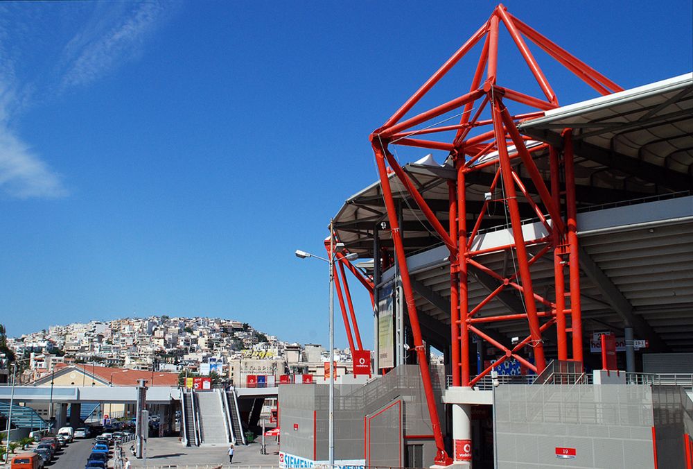 KONTRASTER: Før OL i 2004 fikk også Athens store fotballstolthet, Olympiacos, ny stadion. De 30 meter høye stålkonstruksjonene i rødt står i sterk kontrast til den lave, tradisjonelle greske bebyggelsen bak til venstre i bildet.