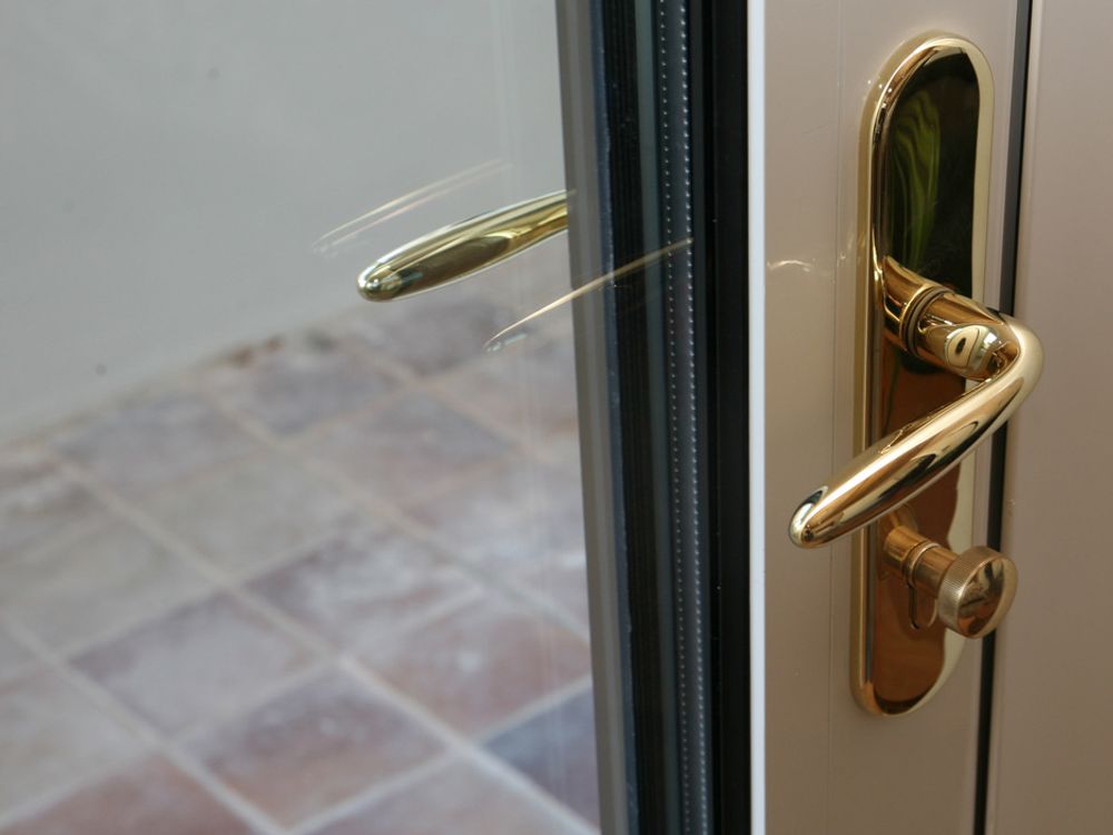 DETALJ: Dørhåndtak i gull på døren ut til terrassen på soverommet.