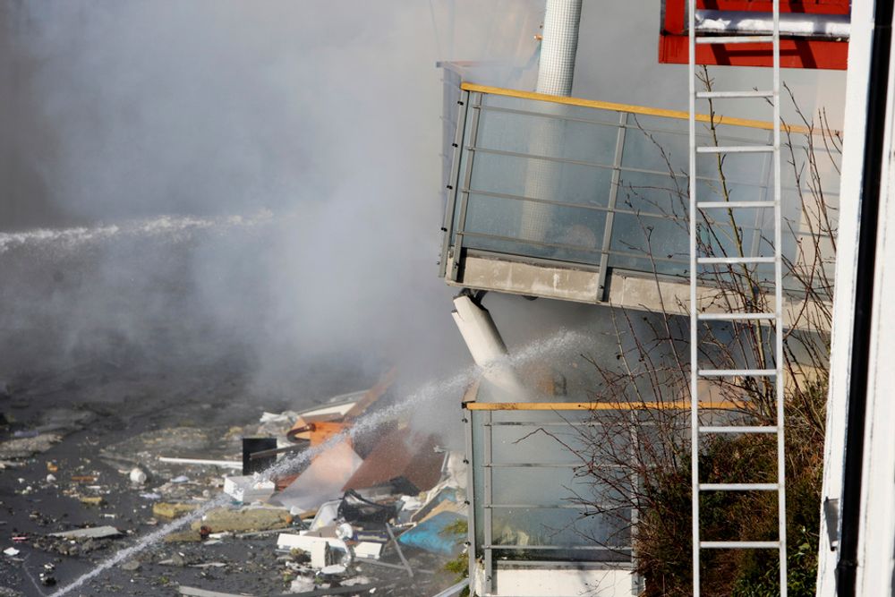 KUNNE EKSPLODERE: Brannvesenet sprøytet onsdag formiddag vann inn i boligblokken som kollapset i Ålesund natt til onsdag. En lekk gasstank i kjelleren gjorde at faren for eksplosjon var stor.
