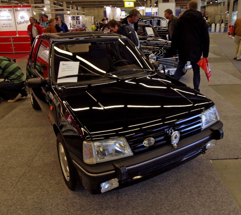 Hva i huleste gjør en Peugeot 205 XS 1991-modell på tidenes råeste norske bilmesse? Jo, denne tilhører utstillingen av den norske kongefamiliens kjøretøy opp gjennom årene. Den strøkne 205-en var 18-årsgaven til kronprins Haakon fra KNA.