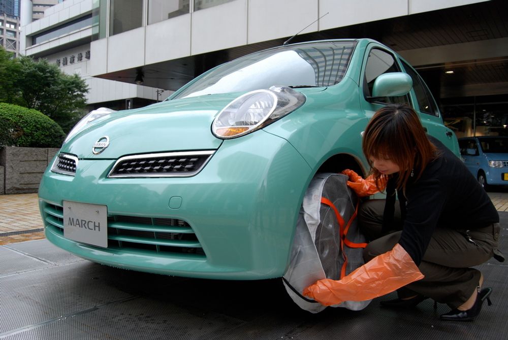 FESTER GREPET: Fra 1. oktober er AutoSock godkjent som originaltilbehør også av Nissan. Asuka Ujita viser hvor enkelt den kan monteres på en Micra (heter March i Japan) foran hovedkvarteret i Tokyo.