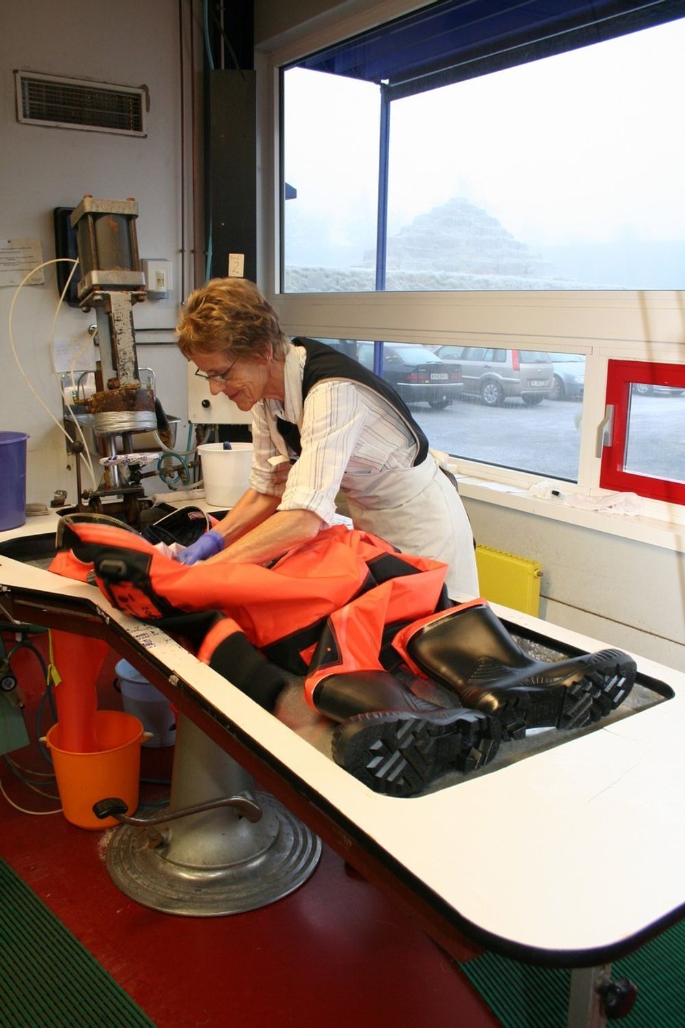 Manuell testing av hver redningsdrakt ved Helly Hansen. Eva Korseth gransker hver lille søm og sammenføying.