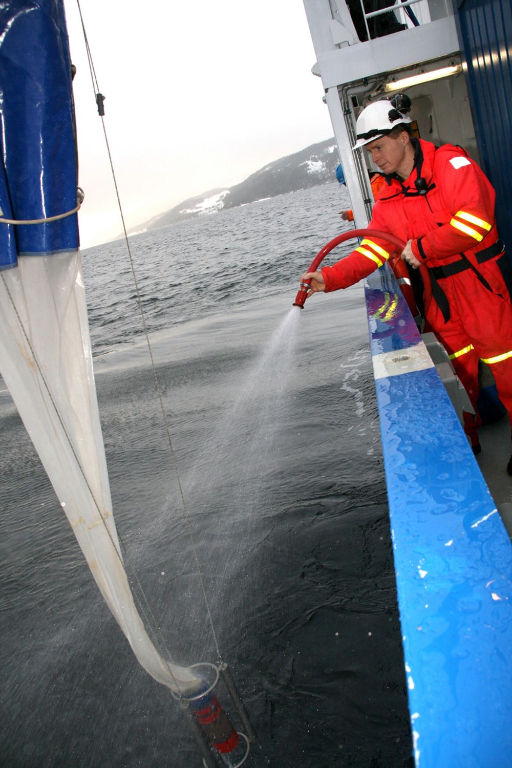 Overingeniør Svenn Ove Linde vasker trålen etter å ha fisket opp materiale fra Trondheimsfjorden med R/V Gunnerus.