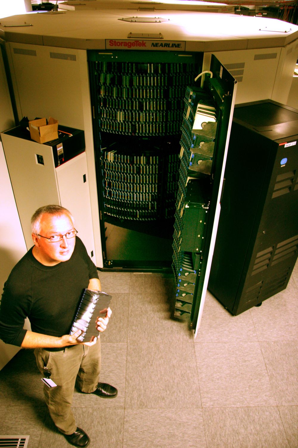 HEMMELIG: Dypt under bakken ligger EDBs stormaskiner for datalagring. Her viser Hans Martin Braathen en robotveksler som behandler datateiper. Til sammen har Braathen ansvaret for 72 terrabyte med lagringskapasitet.