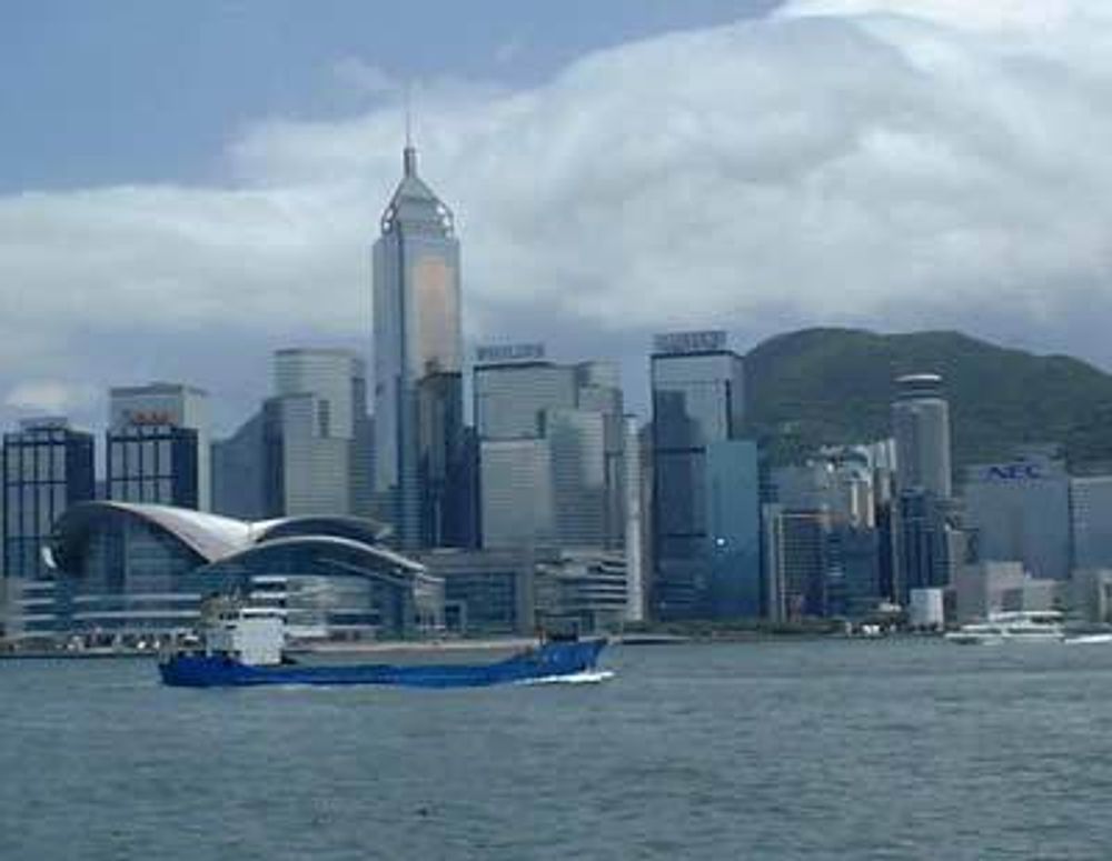 Hong Kong, kina. Skyskrapere sett fra sjøen, med lasteskip foran