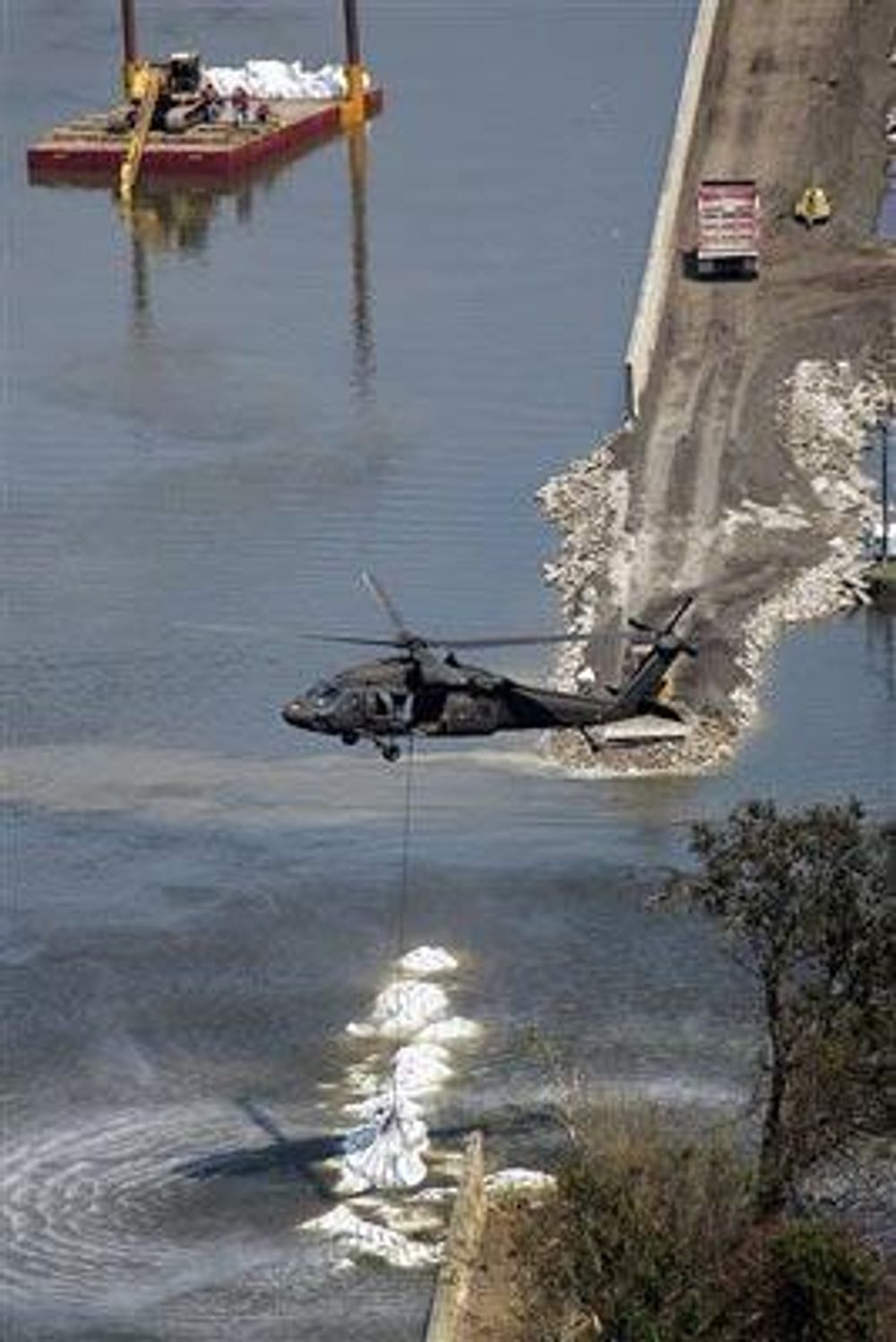 Dikene repareres av US Army Corps of Engineers med Black Hawk helikoptre som dropper sandsekker.