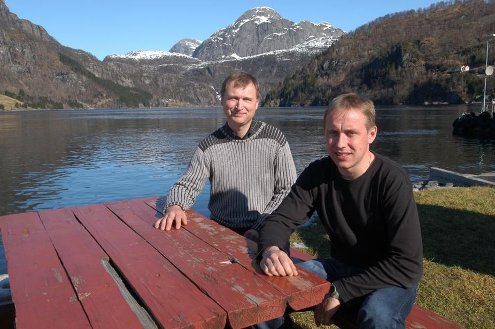 KVALITET: Det er kvalitet å bo i distrikts-Norge mener Ove Mykebust og Johnny Hausbakk. Nå håper de snart at det vil bli bygget bru over fjorden i bakgrunnen.