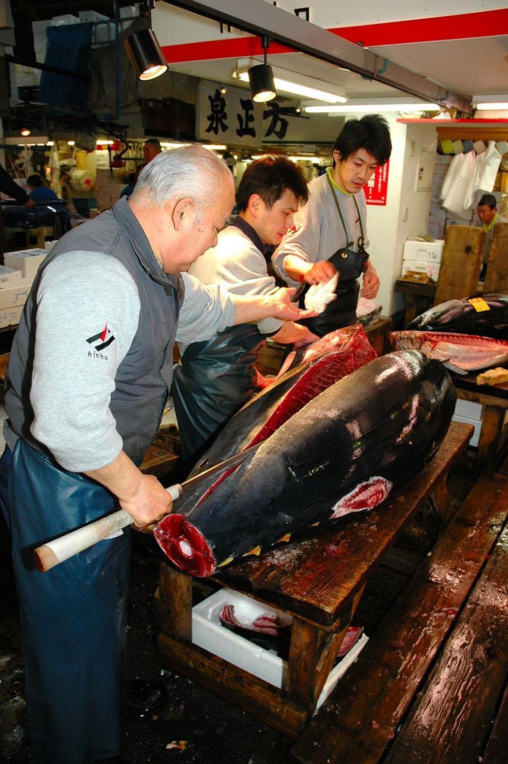TRE MANN: for å skjære nøyaktig i tunfisken må det tre mann til.