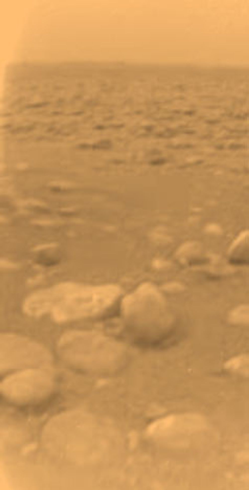 VANNIS: Avrundede blokker på landingsstedet. Blokkene består trolig av skitten vannis. Den største av blokkene i forgrunnen er ca. 15 cm lang og befinner seg omkring 85 cm fra Huygens. Foto: ESA/Nasa/JPL/