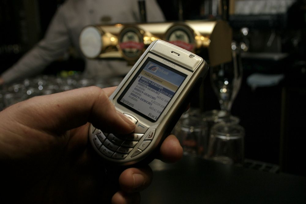 RÅD TIL EN RUNDE TIL? Nå kan du sjekke saldoen mens du venter i baren. Det Nokia-eide selskapet Meridea er i Norge og overbeviser en norsk storbank til å innføre mobile banktjenester. Mobilen på bildet er forresten den aller nyeste UMTS- telefonen til Nokia. 6630.