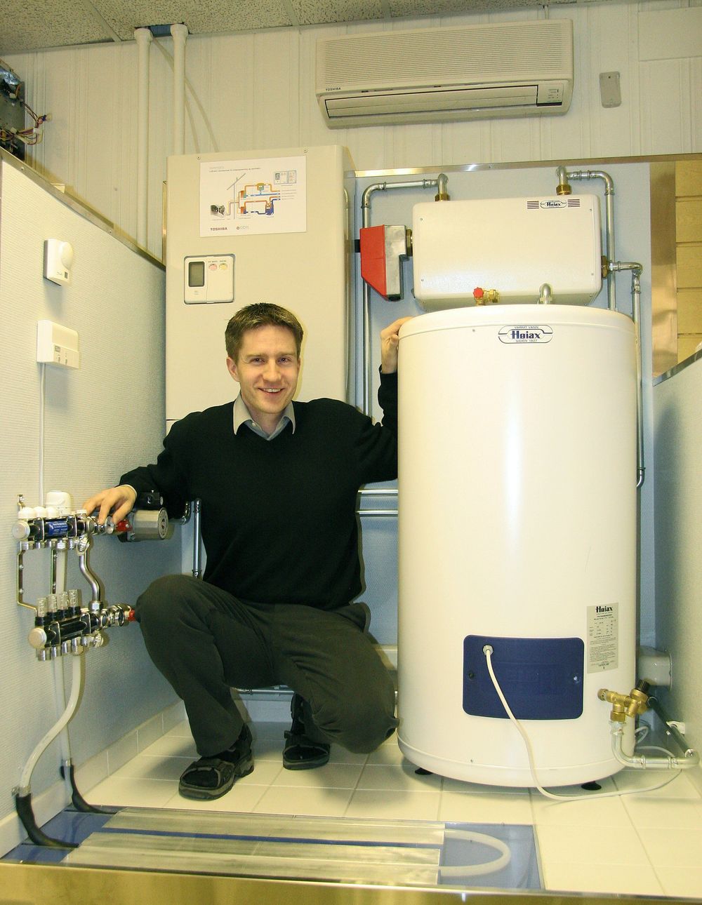 SENTRALANLEGG:Sivilingeniør i kuldeteknikk, Morten Solsem i selskapet ABK har vært med å utvikle en ny type varmepumpeanlegg som bruker utedelen fra en luft-luft-varmepumpe, men som leverer varmt vann til boliger med vannbåren varme. Dette anlegget kan også levere varme til tappevann.