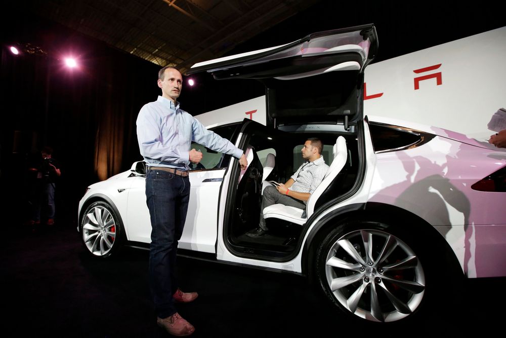 A Tesla executive talks about the features of the Model X car at the company's headquarters Tuesday, Sept. 29, 2015, in Fremont, Calif. CEO Elon Musk said the Model X sets a new bar for automotive engineering, with unique features like rear falcon-wing doors, which open upward, and a driver’s door that opens on approach and closes itself when the driver is inside. (AP Photo/Marcio Jose Sanchez) 