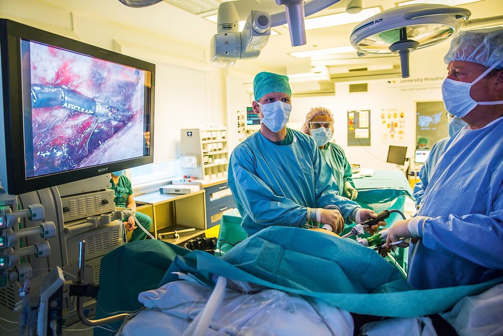 Opererer på skjerm: Kirurg Bjørn Edwin og assisterende kirurg Casper Beiske forsøker å løsne svulsten som har vokst seg enorm inne i leveren på pasienten. 