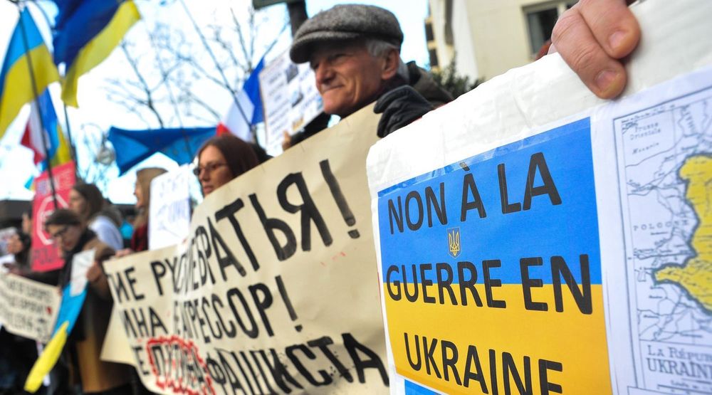PÅ RANDEN AV KRIG: Ukrainere demonstrerer mot Russlands invasjon av Krim-halvøya. Bildet er fra en protestmarkering utenfor den russiske ambassaden i Paris søndag.