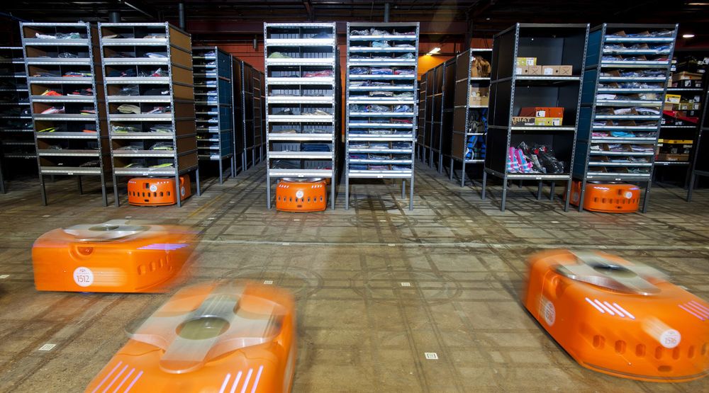 Kiva-robotene er de lave oransje maskinene. De kjører under lagerhyller fulle av varer, og løfter en hel hylle om gangen. Bildet er fra lageret til Acumen Brands. Amazon kjøpte Kiva for over halvannet år siden, og er i gang med å effektivisere sine egne lagre.