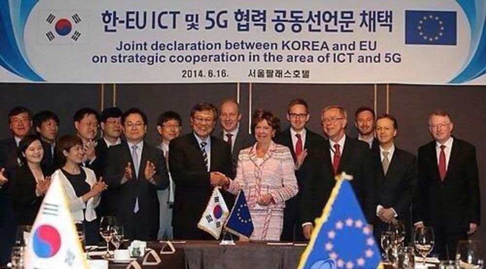 Mun-Kee Choi og Neelie Kroes gratulerer hverandre etter å ha undertegnet en samarbeidsavtale om utvikling av 5G mellom Sør-Korea og EU. 