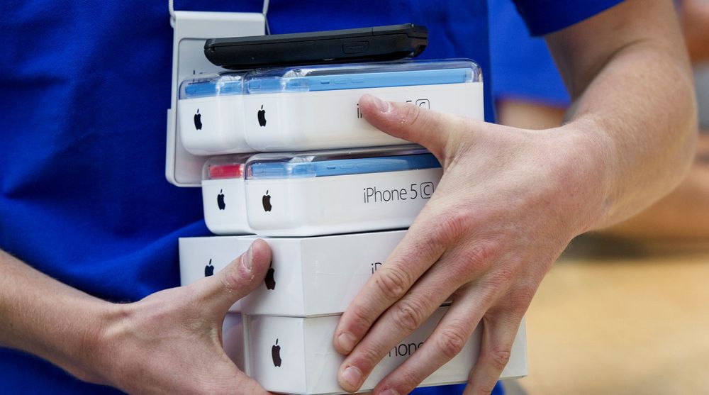 iPhone 5C og 5S fikk bein å gå på da salget startet forrige fredag. I løpet av helgen har Apple solgt 9 millioner telefoner. Bildet er av en Apple Store-ansatt som bærer ut telefoner i selskapets butikk i Palo Alto.