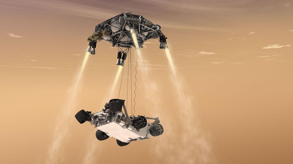 Landing i liner:  Illustrasjon av Sky Crane-konseptet under landingen av Curiosity i Gale-krateret på Mars 6. august 2012 – roveren blir senket til overflaten fra rakettplattformen i en høyde av 7,5 meter ved hjelp av tre nylonliner. Mars 2020 vil bruke det samme konseptet.