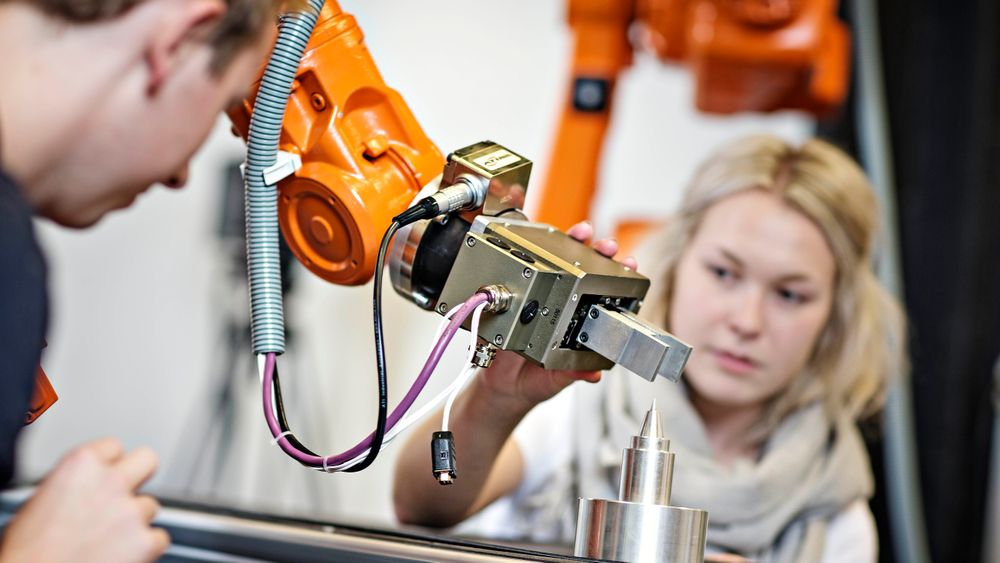 To studenter arbeider med en Chunk-griper på en ABB industrirobot.