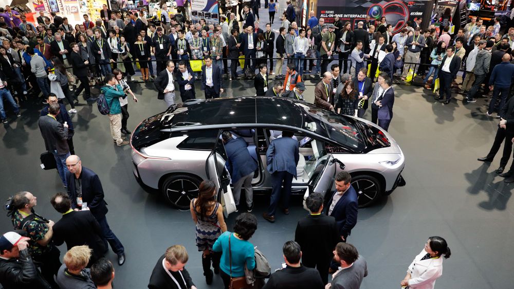 People gather around the Faraday Future's FF91 electric car at CES International Thursday, Jan. 5, 2017, in Las Vegas. (AP Photo/Jae C. Hong)