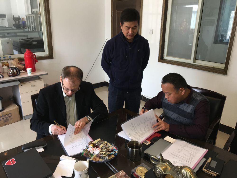 Kontrakten signeres på fabrikken i Fuyang. Oscar Olsen til venstre. AG-representant i Kina, Liao Honglei stående i midten og fabrikkeier Liu Lin til høyre.