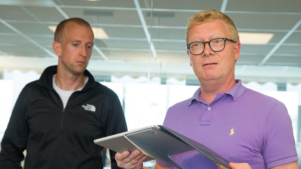 Gunnar Greve (til venstre) og Christian Almskog, Direktør for Windows og Devices i Microsoft Norge under et arrangement hos Greves produksjonsselskap Mer. Her viser Almskog frem ett av Surface-produktene som Mer nå tar i bruk.