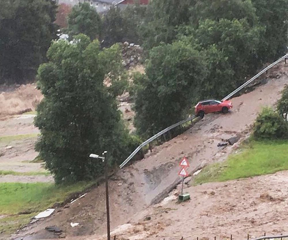 Mobilbilde tatt mens uværet sto på, og en dil er i ferd med å bli tatt av vannmassene.