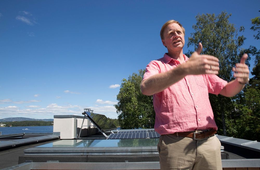 Bjørn Haugland på taket av huset sitt på Nesøya med solcellene i bakgrunnen.