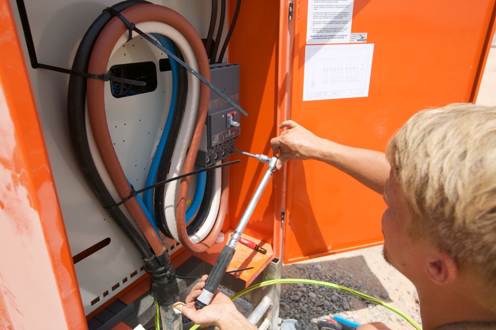 En elektriker gjør klart strømskap for Camp Midgard i Irak.