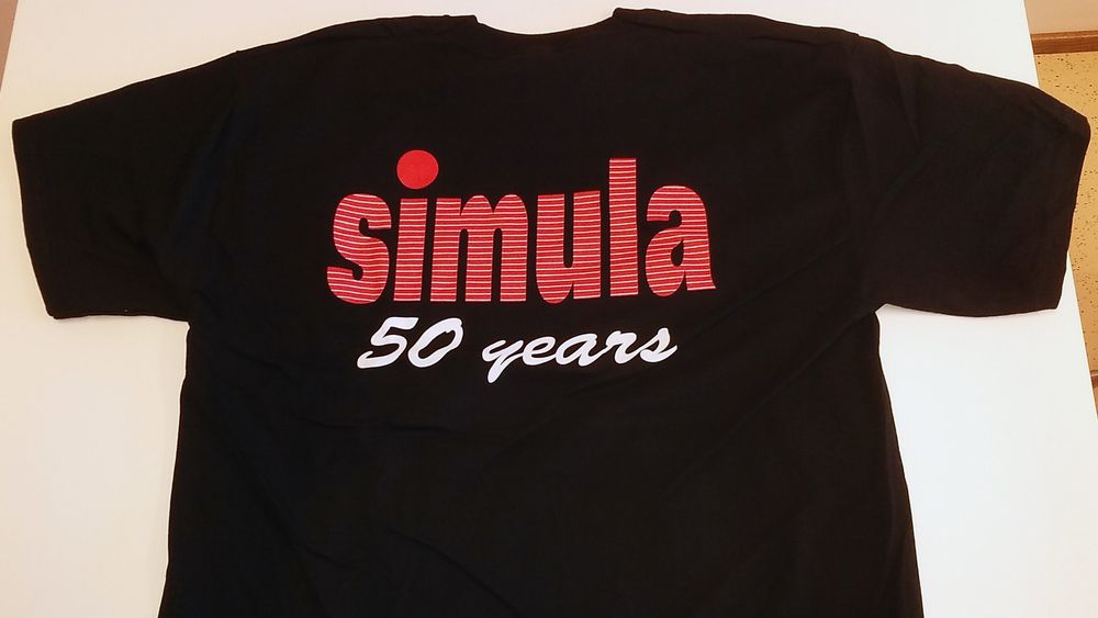 Jubileums-t-skjorten for Simula. Dette er baksiden. Foran er det en mindre tekst som sier «Simula does it with class»