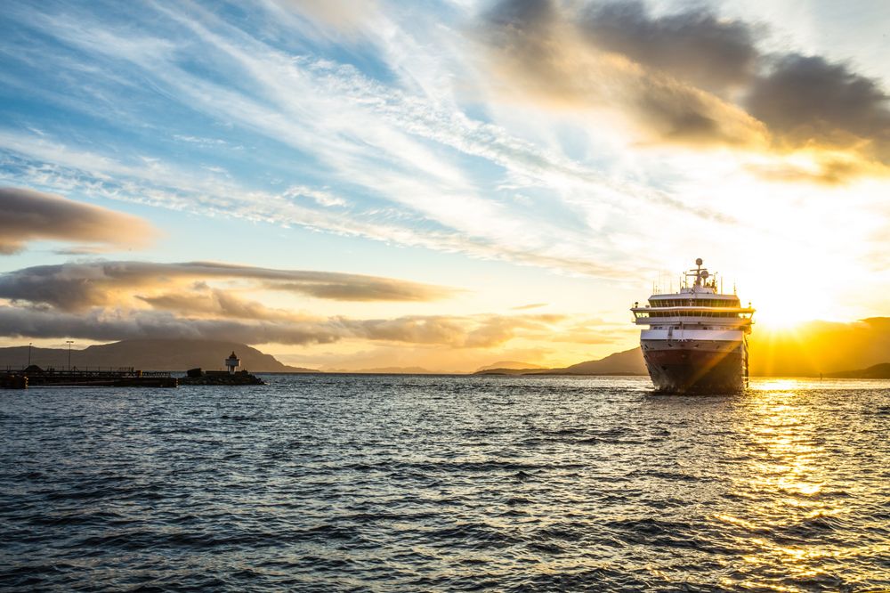 MS Nordkapp i solnedgang. Hurtigruten ASA vil fortsette å seile kystruten Bergen-Kirkenes og vil søke alle tre anbudene.