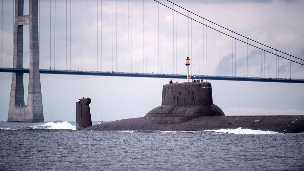 ILLUSTRASJONSBILDE: Den digre, russiske atomubåten Dmitrij Donskoj seiler under Storbæltbroen i Danmark i juli 2017. Men det er ikke helt denne typen ubåter som nå vekker bekymring i Nato-kretser.