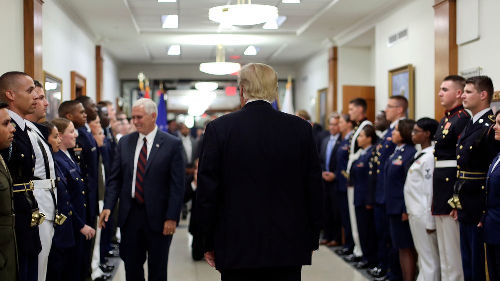 President Donald Trump (med ryggen til kamera) og visepresident Mike Pence hilste på amerikanske soldater i vestfløyen i Det hvite hus i fjor sommer.