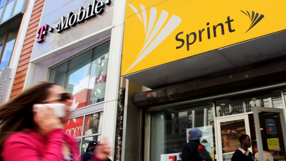 En kvinne går forbi T-Mobile og Sprint-butikker i New York.