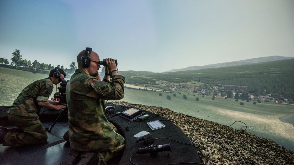 Lasse Amundsen (i front) skuer utover landskapet nær Mjøsa gjennom den digitale kikkerten. Kristian (bak) leter etter fienden gjennom ildlederinstrumentet FOI2000.