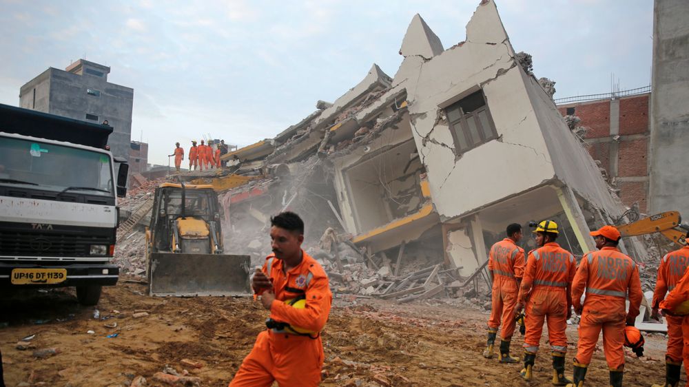 Redningsmannskaper jobbet gjennom natta for å rydde ruinene etter at to bygninger kollapset utenfor New Delhi i India. Så langt er tre personer funnet døde. 