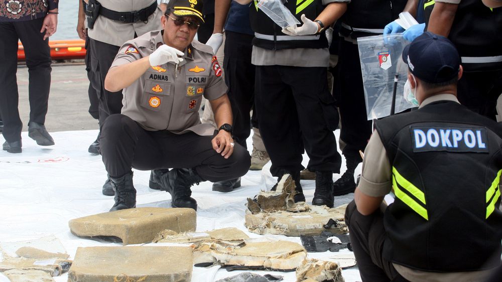 Vrakrester etter gårsdagens flystyrt undersøkes av indonesisk personell.
