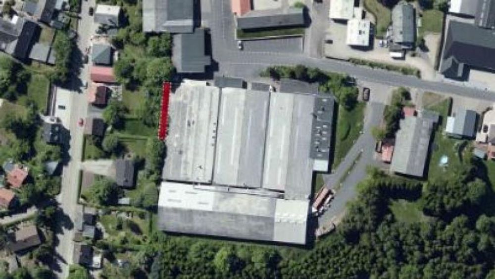 Den røde markeringen viser hvor entreprenørmaskiner borer opp 200 tonn forurenset jord i den danske småbyen Them. De fire store produksjonsbygningene er sykkelprodusenten Winther. 
