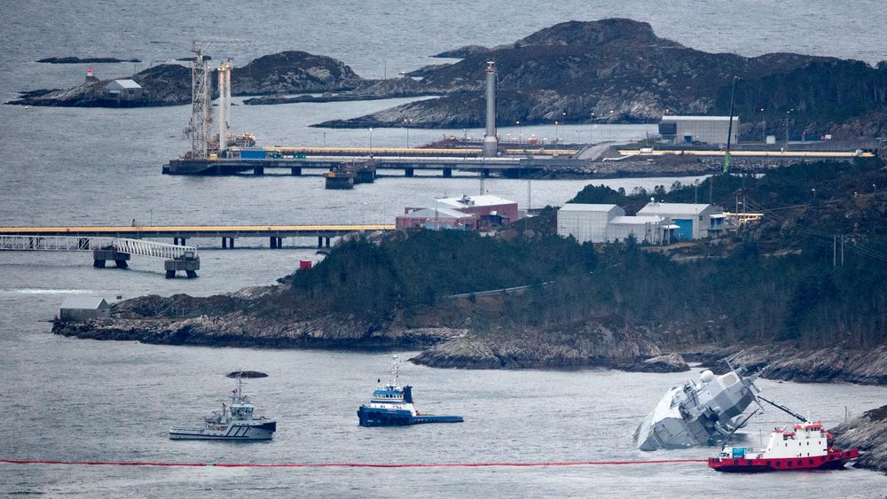Den norske fregatten "KNM Helge Ingstad" ligger med slagside nær land etter at den kolliderte med tankskipet "Sola" natt til torsdag. Deler av Stureterminalen i bakgrunnen.