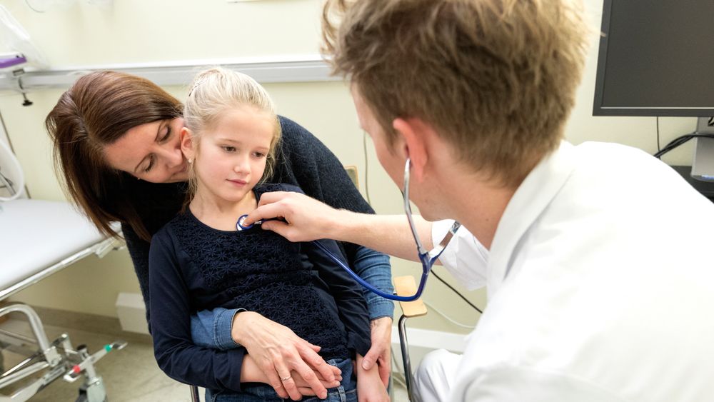 Fastlege lytter med stetoskop på et barn.