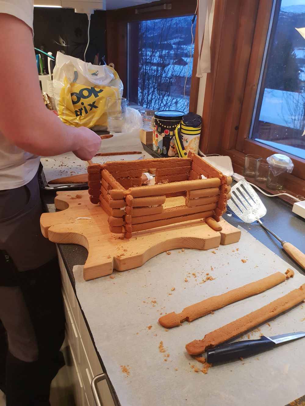 Fra byggeprosessen der Inger lise Elgaaen og Henrik Løkken lafter en gammel seterstue med pepperkake som byggemateriale.