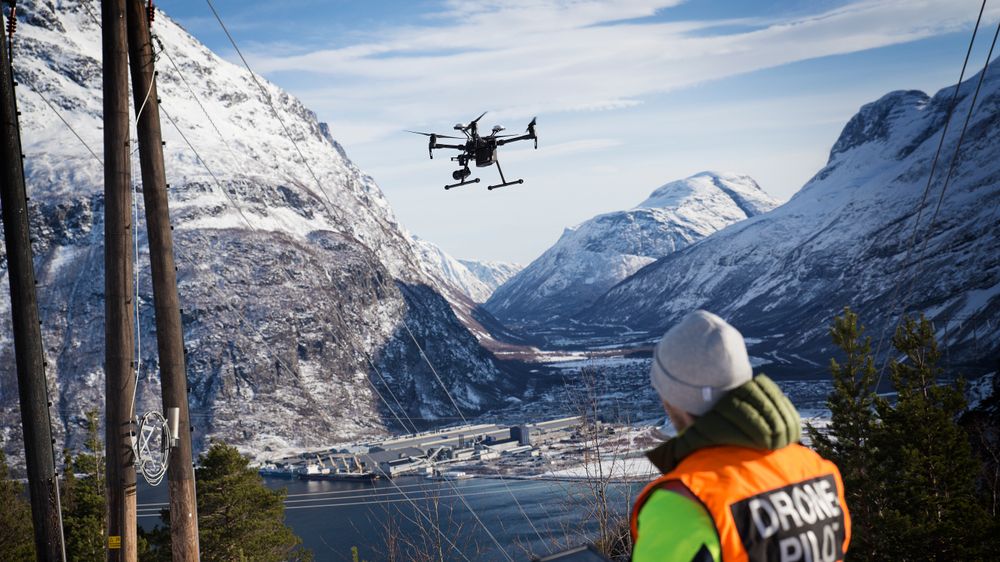 Dronepilot Thomas Negård demonstrerer en DJI-drone ved kraftlinjen som går ned til Hydro Aluminium på Sunndalsøra. Dette er et av stedene Esmart systems samarbeider med Statnett om å finne feil på kraftnettet.