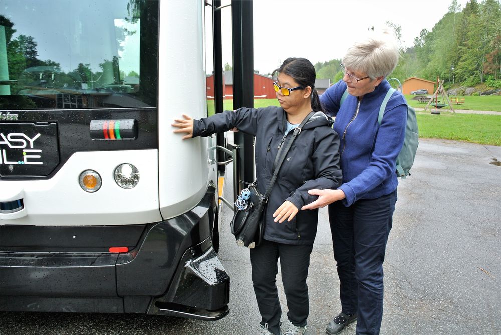 Døvblinde Rachada Chotsuk bruker hendene til å bli kjent med bussen før hun går ombord. Her får hun hjelp av Inger Svendsen.  