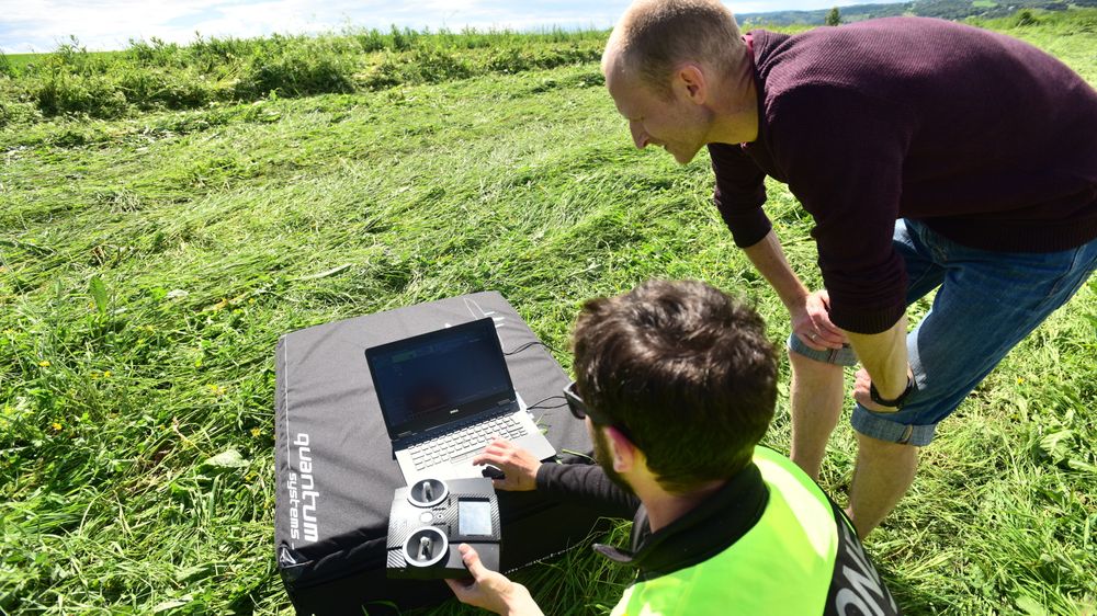 Dronen til Nibio har en flytid på én time. Da rekker det over et område på rundt 1000 mål. Her sjekker Stefano Puliti (sittende) bildene som dronen har tatt mens Arne Steffenrem følger med.
