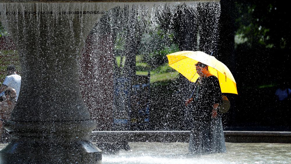 En kvinne kjøler seg ned i fontenen i Frankfurt torsdag. 
