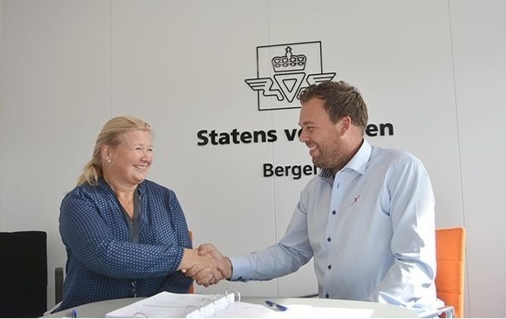 Avd.dir. Grethe Vikane i Statens vegvesen gratulerer daglig leder Knut Brusletto i Contexco AS med kontrakten.