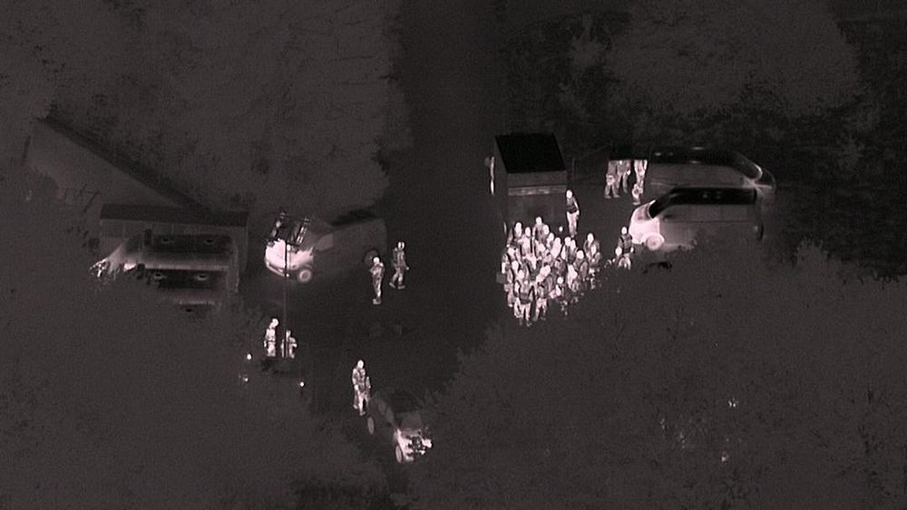 Dronebilde tatt med nattkamera som trolig viser politiet før razziaen.