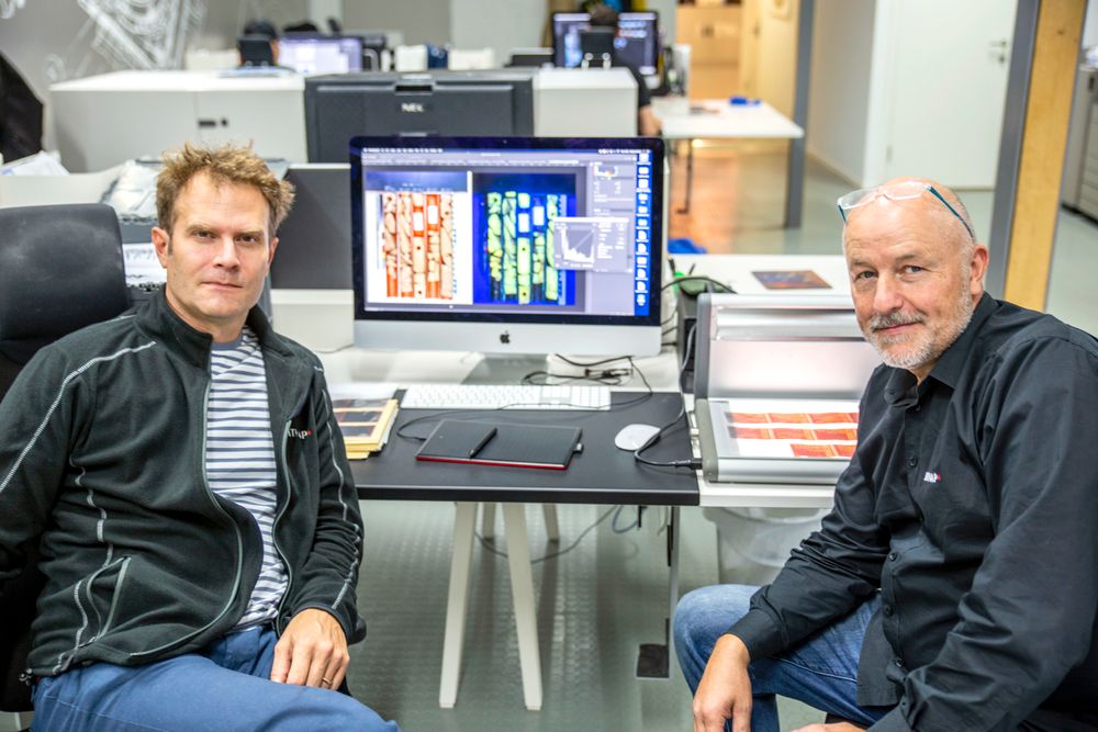 Fotograf Markus Johansson og daglig leder Dag Myrestrand i Bitmap skal skanne tilsammen 30.000 negativer i ulike størrelser. På skjermen vises et bilde av en kjerneprøve. Til venstre er bildet tatt med hvitt lys, til høyre med UV-lys som lyser gult der det er hydrokarboner.