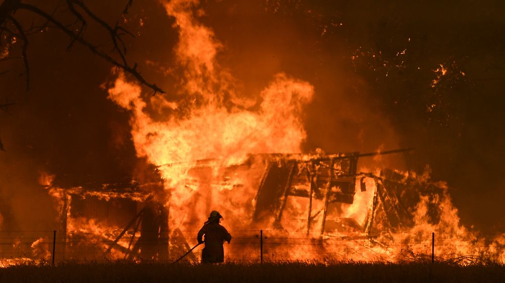 En brannmann kjemper mot flammene i Gospers Mountain i Bilpin, Australia. Nå har landet satt inn militære reservestyrker for å få bukt med krisa.